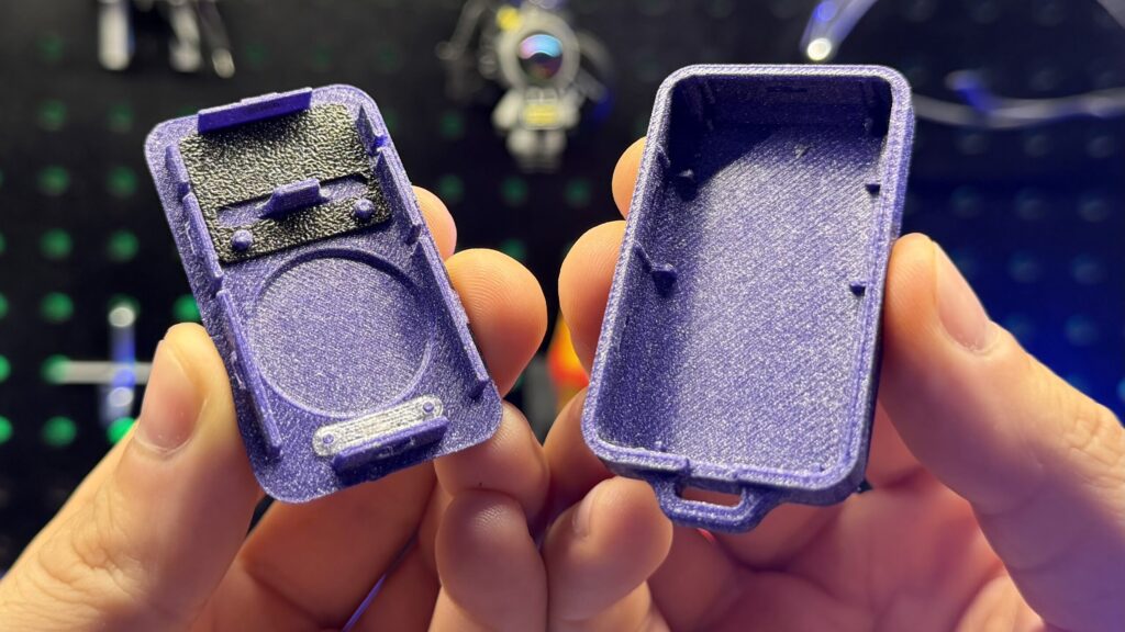 A pair of purple 3D-printed garage door remote keyfob halves held in two hands.